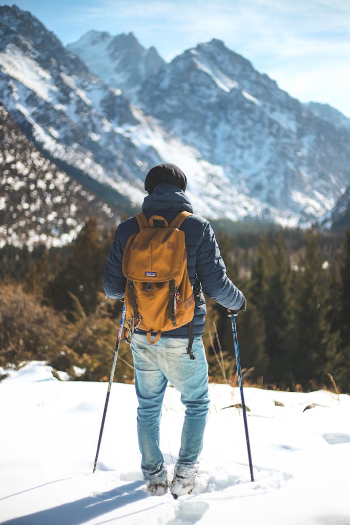 Eco friendly retreat venue | Imagine Greece Retreats A hiker with a backpack traverses a snowy mountain landscape, showcasing winter exploration and adventure.